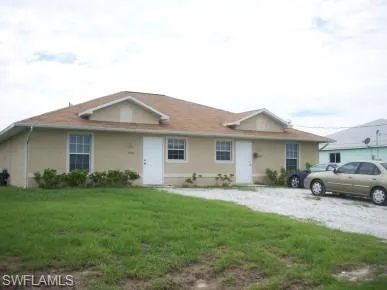Duplex property featuring stucco exterior, a brown shingle roof, and multiple front entrances