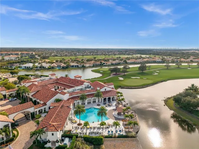 Aerial view of residential area featuring a nearby body of water and a golf club