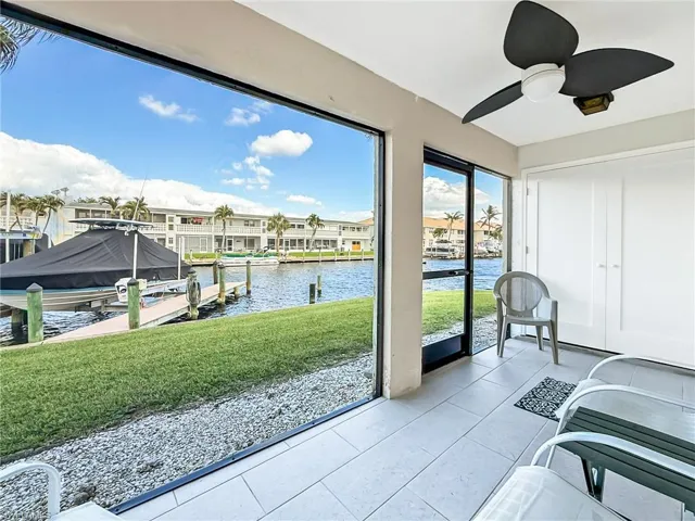 Sunroom with ceiling fan and a water view