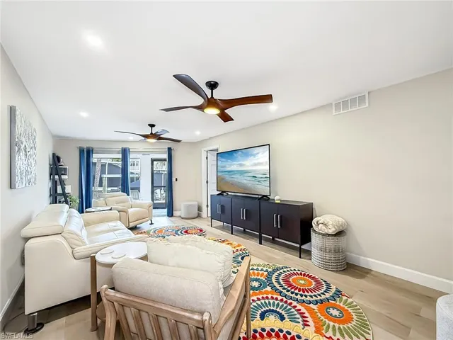 Living room with ceiling fan and light hardwood / wood-style floors