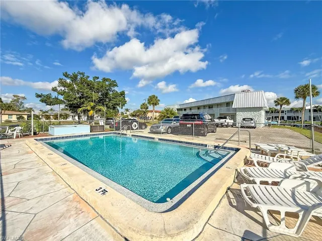 Community pool with a patio area and fence