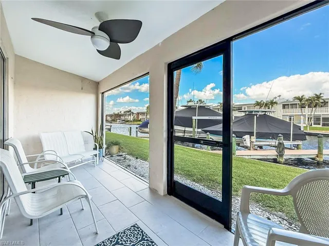 Sunroom with ceiling fan and a water view