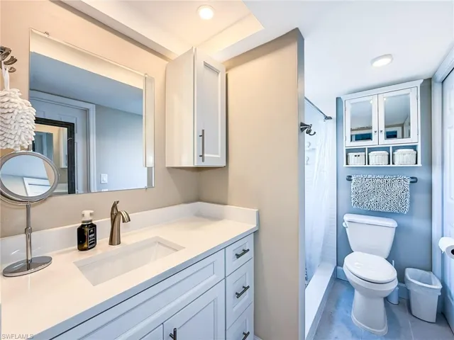 Bathroom featuring a shower with curtain, vanity, toilet, and tile patterned floors