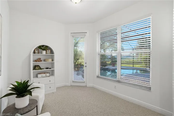 Situated just off the primary bedroom with a bright sunrise  view of the pool and a private full light glass door leading out to the expanded pool lanai.