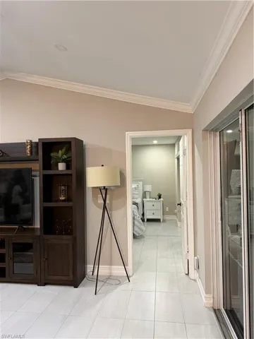 Corridor with light tile patterned floors and ornamental molding