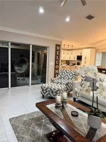 Living area featuring ornamental molding, light tile patterned floors, and ceiling fan