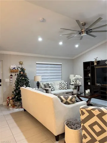Living area with ornamental molding, a ceiling fan, recessed lighting, and tile patterned floors
