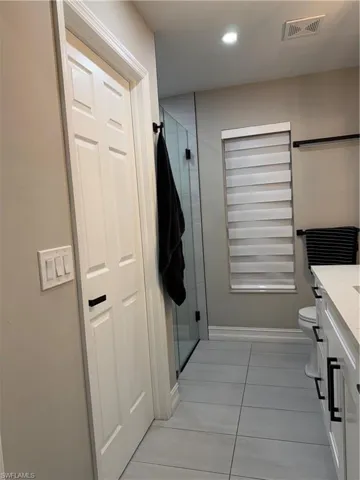 Full bathroom with vanity, a stall shower, light tile patterned floors, and recessed lighting