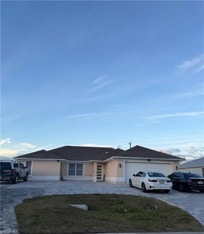 Ranch-style house with driveway, a shingled roof, and a garage