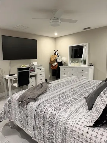 Tiled bedroom with a ceiling fan
