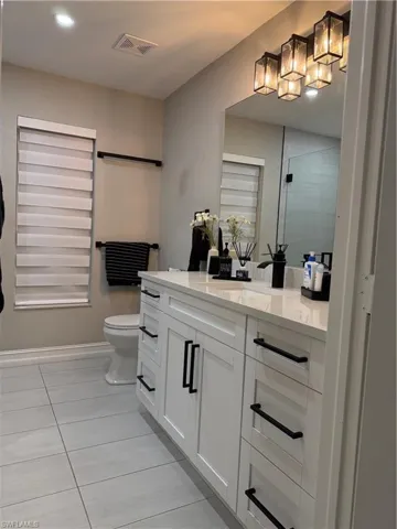 Bathroom featuring vanity, light tile patterned flooring, a shower stall, and recessed lighting