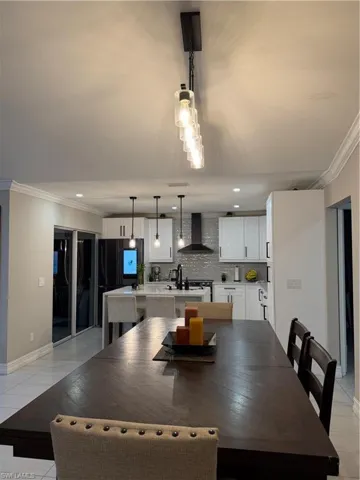 Dining room featuring ornamental molding, light tile patterned floors, and recessed lighting