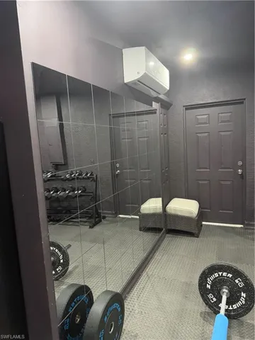 Bathroom with a wall mounted air conditioner and a textured wall