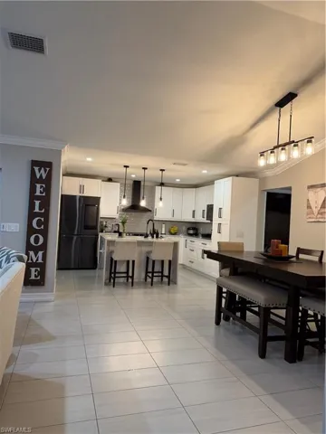Dining room featuring recessed lighting, light tile patterned floors, and crown molding