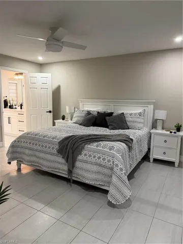 Bedroom with a ceiling fan, ensuite bathroom, recessed lighting, and light tile patterned flooring