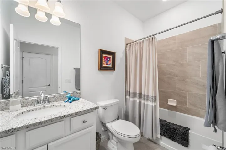 Full bathroom with shower / tub combo, tile patterned flooring, toilet, and vanity