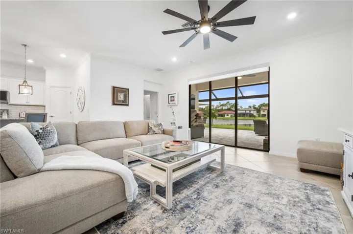 Tiled living room with ceiling fan and ornamental molding