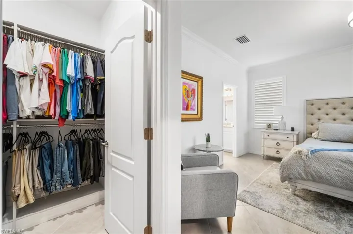 Bedroom with crown molding and a closet