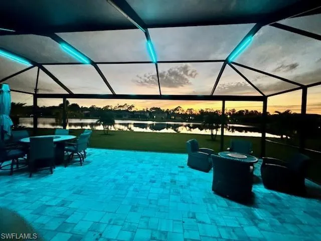 Patio terrace at dusk featuring a water view