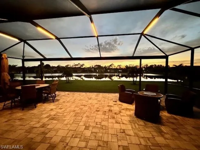 Patio terrace at dusk with a water view and a lanai