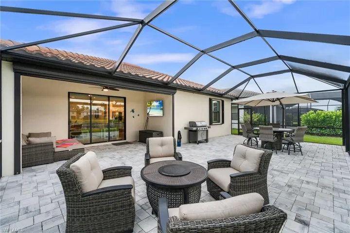 View of patio / terrace featuring a lanai, an outdoor living space with a fire pit, and grilling area