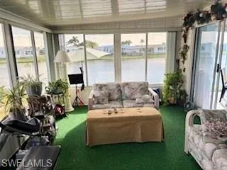 Sunroom with a water view and carpet floors