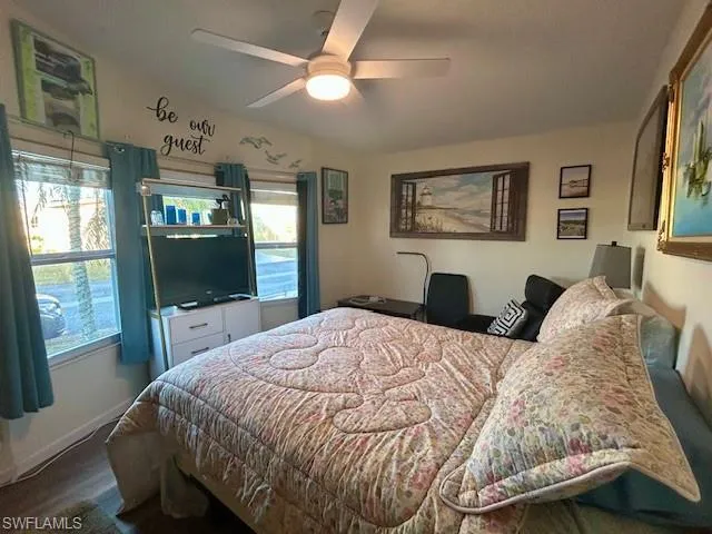 Bedroom with a ceiling fan and dark wood-style flooring