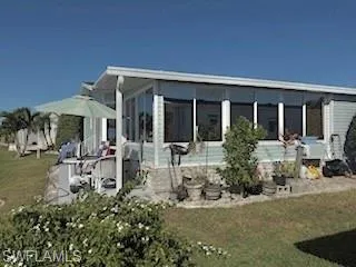 View of property exterior featuring a yard and a sunroom