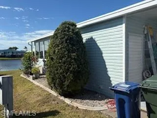 View of property exterior with a water view and a yard