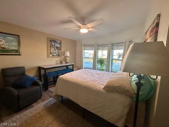 Bedroom featuring a textured ceiling, wood finished floors, and ceiling fan