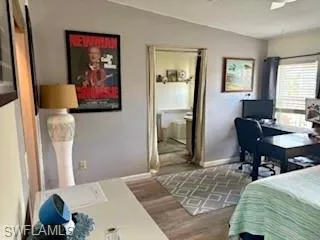Master Bedroom with a desk, light wood-style flooring, ensuite bath, and a textured ceiling