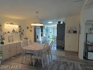 Dining room with wood-type flooring and baseboards