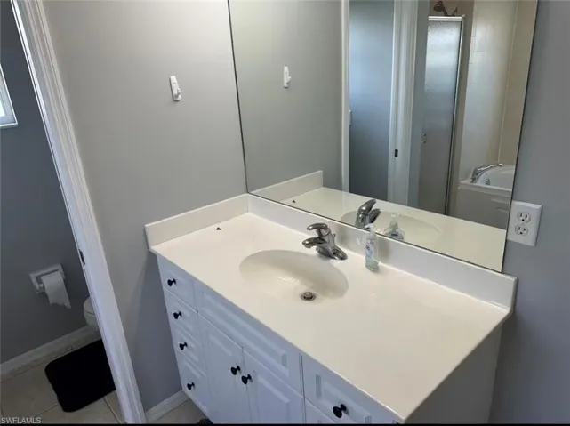 Bathroom featuring vanity, a stall shower, and a bath