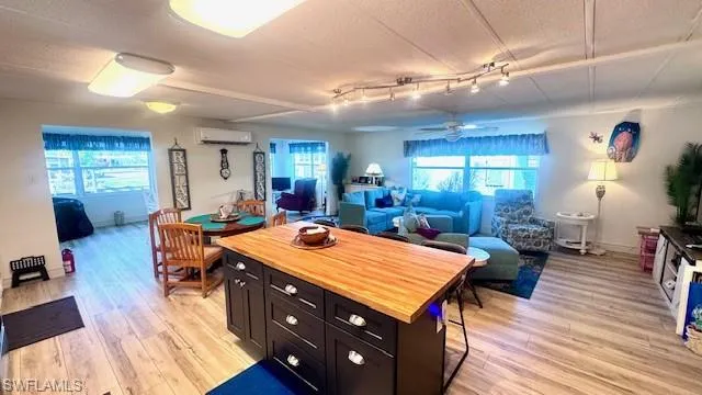 Kitchen with butcher block countertops, plenty of natural light, light wood-style flooring, and a textured ceiling