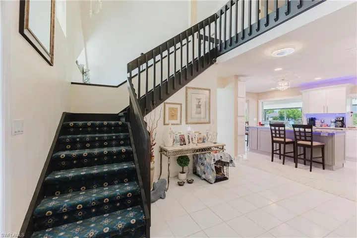 Stairs with a high ceiling and tile patterned flooring