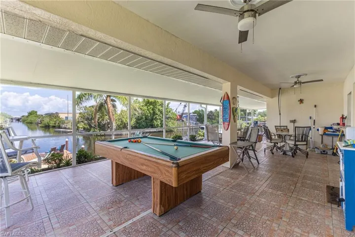 Playroom featuring billiards table, a ceiling fan, and a water view