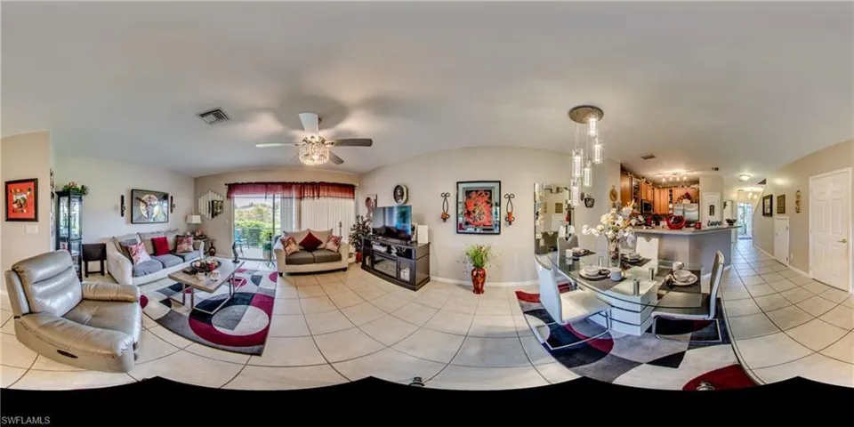 Living room featuring light tile patterned floors, lofted ceiling, and a ceiling fan