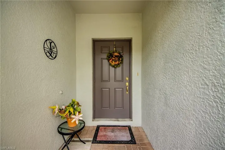 Doorway to property featuring stucco siding