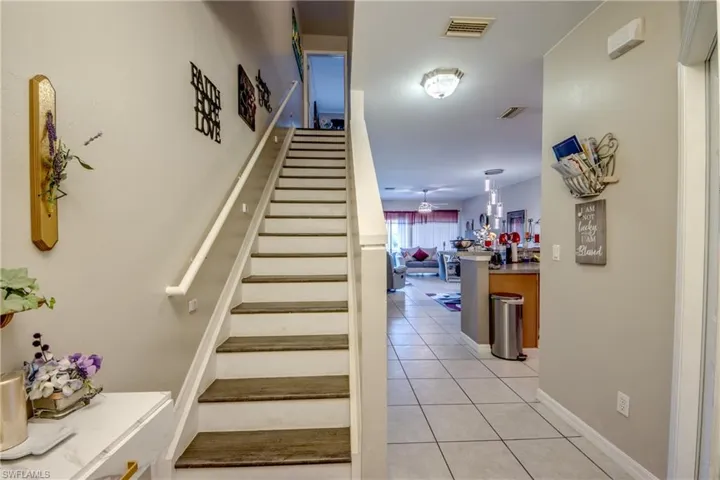 Stairway with tile patterned floors and baseboards