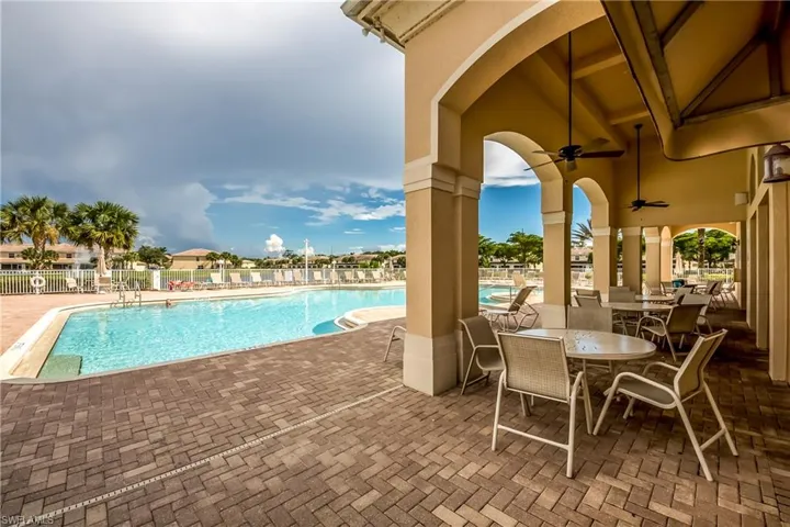 Community pool featuring a patio area and a ceiling fan