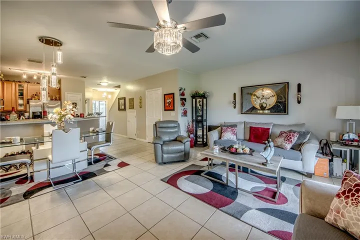 Living area featuring light tile patterned flooring and ceiling fan