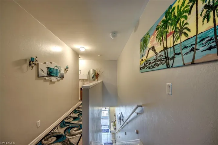 Hallway with an upstairs landing and a textured wall