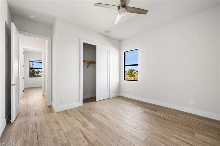 Unfurnished bedroom featuring multiple windows, ceiling fan, and light hardwood / wood-style flooring