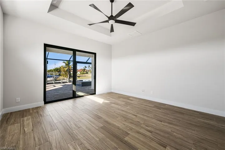 Spare room featuring a raised ceiling and ceiling fan