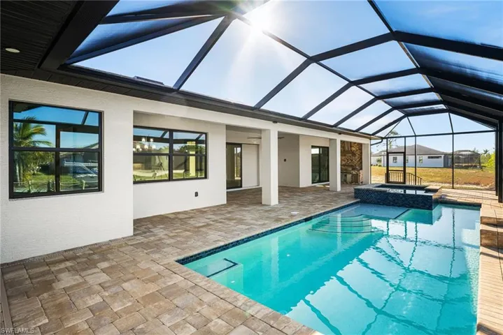 View of pool with a lanai, an in ground hot tub, and a patio