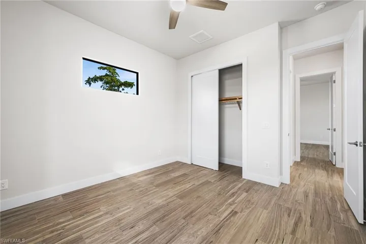 Unfurnished bedroom featuring light wood-type flooring, a closet, and ceiling fan