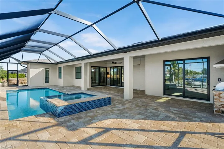 View of pool with a lanai, a patio area, an in ground hot tub, and ceiling fan