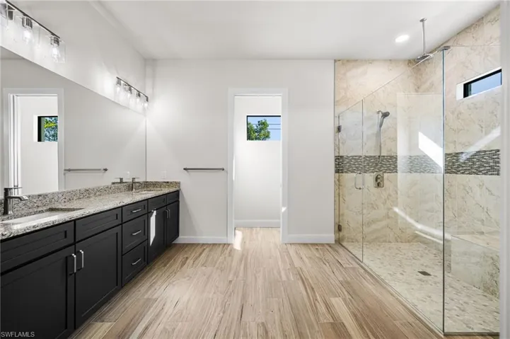 Bathroom featuring vanity, an enclosed shower, and wood-type flooring