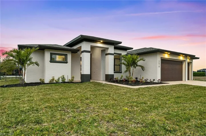 Modern-style house featuring a garage and a lawn