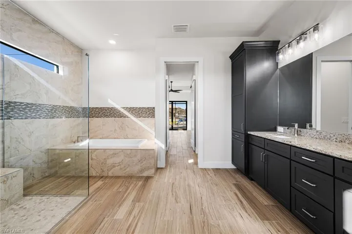 Bathroom with plus walk in shower, vanity, and ceiling fan